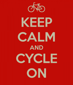 红色背景的白色文字写着“保持冷静，继续前进”。文字上方有一辆白色自行车的图片。