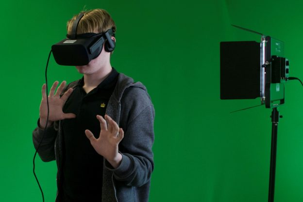 在绿色房间里戴着VR头盔的人