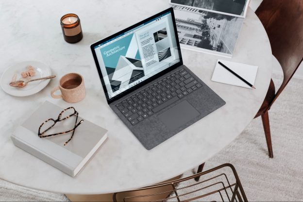 笔记本电脑，笔记本，眼镜和一杯茶。