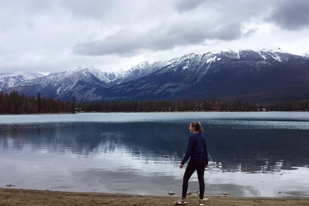 学生阿拉娜站在加拿大的湖泊和雪山前