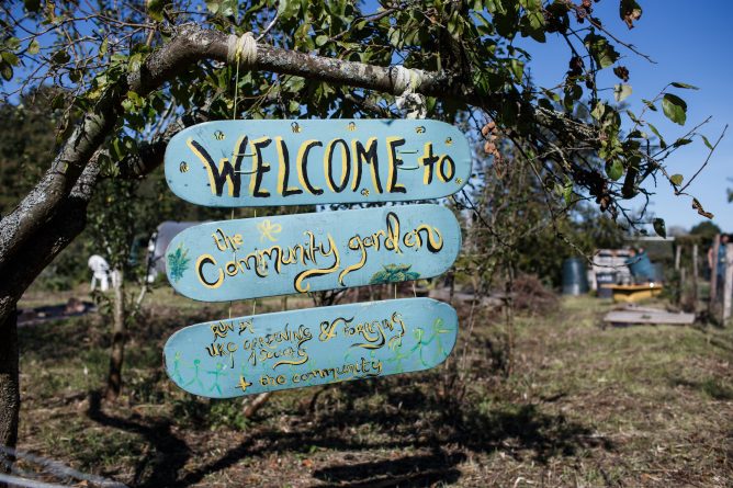 木制标牌上写着:欢迎光临社区花园