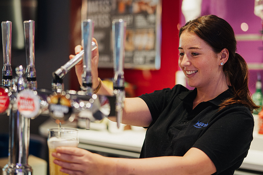 A Food & Beverage Assistant pulling a pint of beer in Mungo's